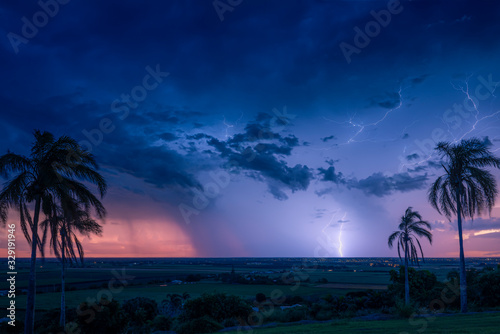 A thunder storm crosses the horizon behind the city of Bundaberg on sunset.