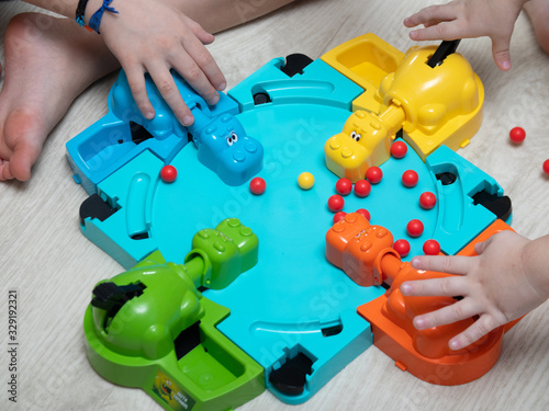 Children play a fun Board game where hippos eat balls. reaction games. educational games for children. children's hands close up