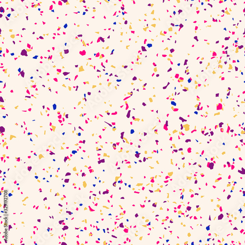Colorful confetti seamless pattern. Vector abstract background with small randomly scattered dots. Terrazzo mosaic texture. Bright pink, purple, blue, yellow spots on beige backdrop. Trendy design