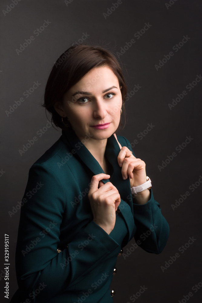 Fototapeta premium brunette with short hair in a green dress. Photo on a dark Studio background.