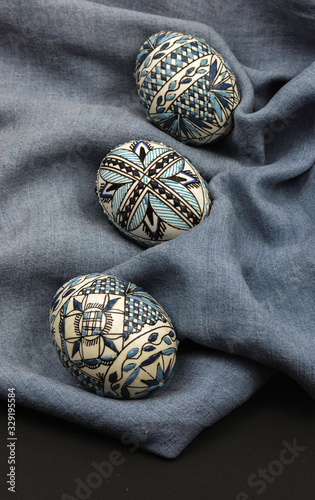 Easter eggs icons set decorated in traditional romania. The colors of the eggs are black, blue and white. They are in a blue cloth font.