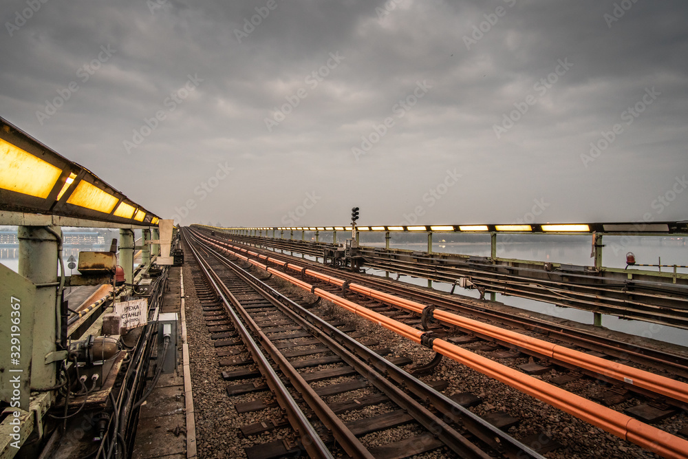 Open subway way at dusk, illuminated by lamps.