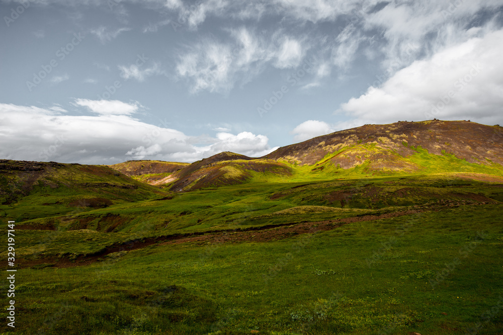 Wonderful icelandic nature landscape. View from the top. High mountains, mountain river and green grassland. Green meadows. Iceland.