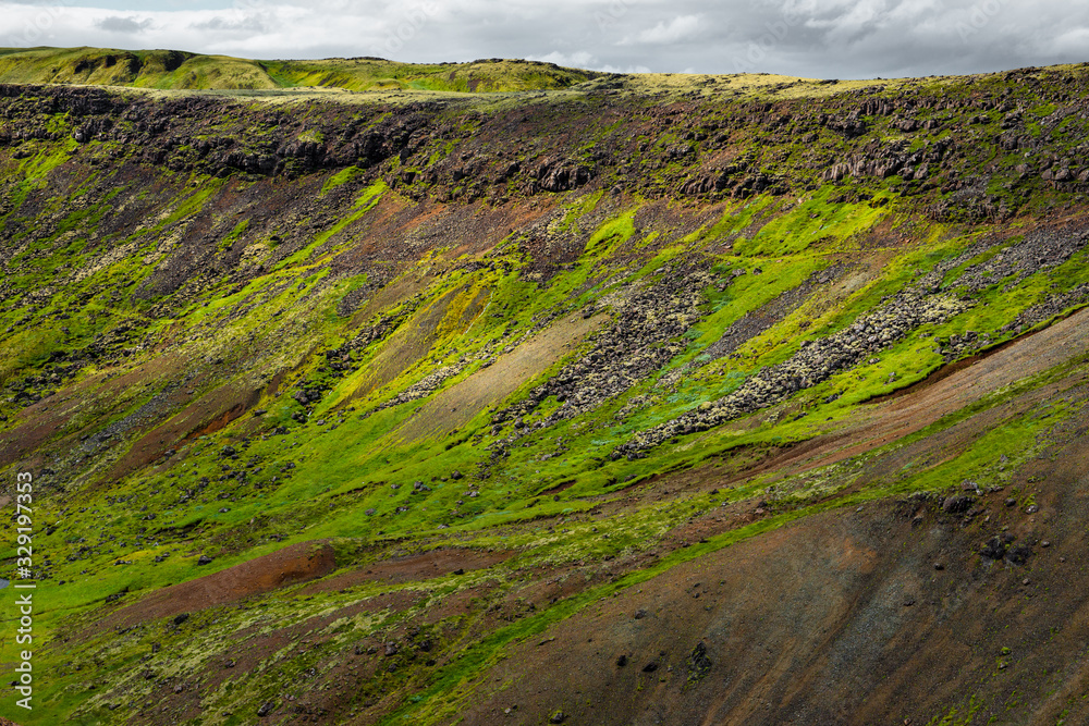 Wonderful icelandic nature landscape. View from the top. High mountains, mountain river and green grassland. Green meadows. Iceland.