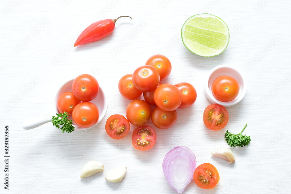 Fototapeta premium Fresh cherry tomato, displayed in containers on white wooden background