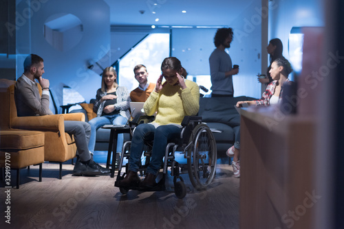 Handicapped young woman with colleagues working in office. Performing in co-working space. Office people working together.