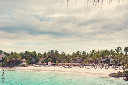 Fototapeta Naklejka Na Ścianę i Meble -  Tropical beach with rocks and coconut palm trees, color toned picture