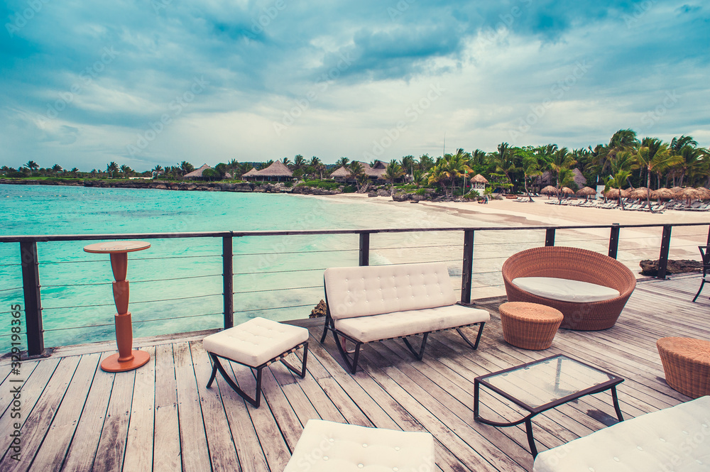 Outdoor terrace with Empty wooden table and chair with Sea view of Indain ocean, Maldives background. Chairs, table and sofa at the Terrace with panorama view of sea. Outdoor terrace with Empty wooden table and chair with Sea view of Indain ocean, Maldives background. Chairs, table and sofa at the Terrace with panorama view of sea.