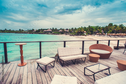 Outdoor terrace with Empty wooden table and chair with Sea view of Indain ocean, Maldives background. Chairs, table and sofa at the Terrace with panorama view of sea.