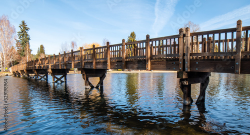 Fotografie Wood pedestrian walking and bike bridge over Deschutes River in Drake Park, Bend, Oregon