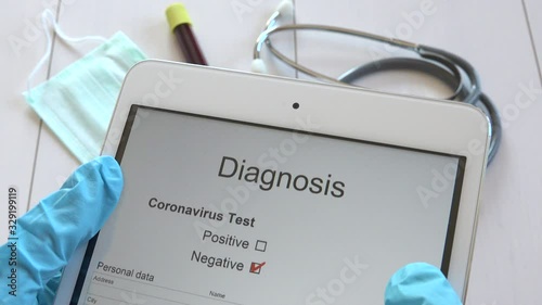Medical doctor reading COVID-19 disease negative test results on tablet, physician with blue gloves receiving Sars-CoV-2 check up results, nurse hands getting Coronavirus 2019-nCoV diagnosis on pad