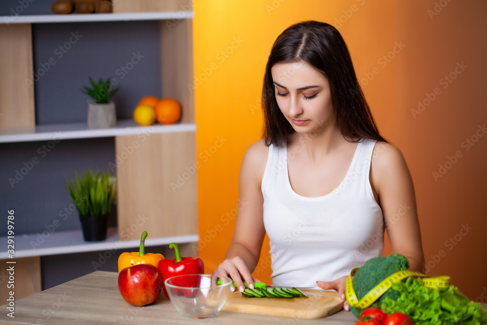 Young beautiful girl prepares a useful diet salad