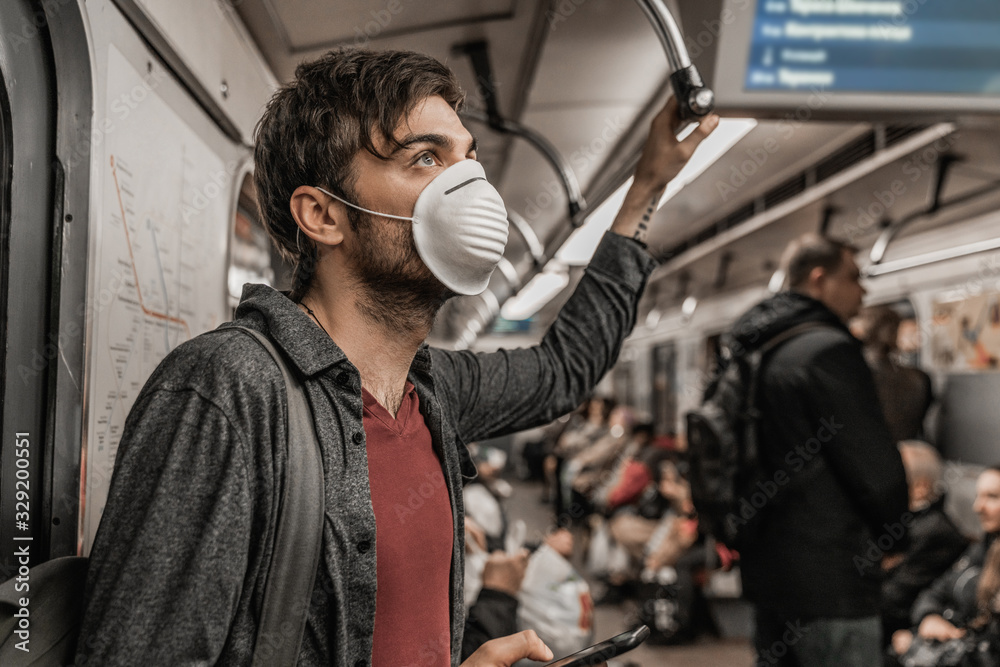 Young male in protective mask in subway train. Health awareness for protection Young male in protective mask in subway train. Health awareness for protection