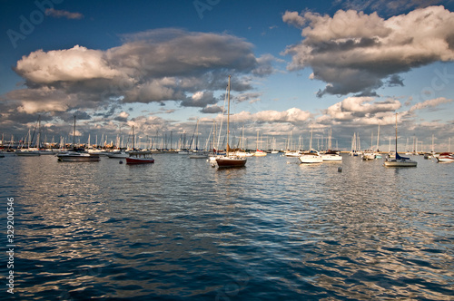Sailboats rest peacefully at their moorings as the sun sets on Burnham Harbor, Chicago lakefront.