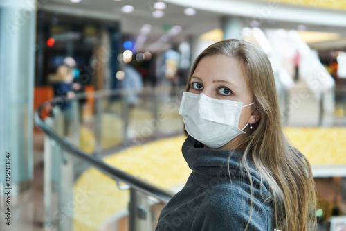 young woman in a surgical mask in a public space