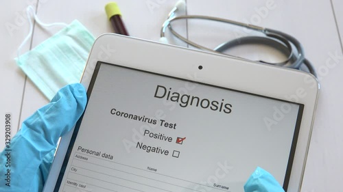 Medical doctor reading COVID-19 disease positive test results on tablet, physician with blue gloves receiving Sars-CoV-2 check up results, nurse hands getting Coronavirus 2019-nCoV diagnosis on pad