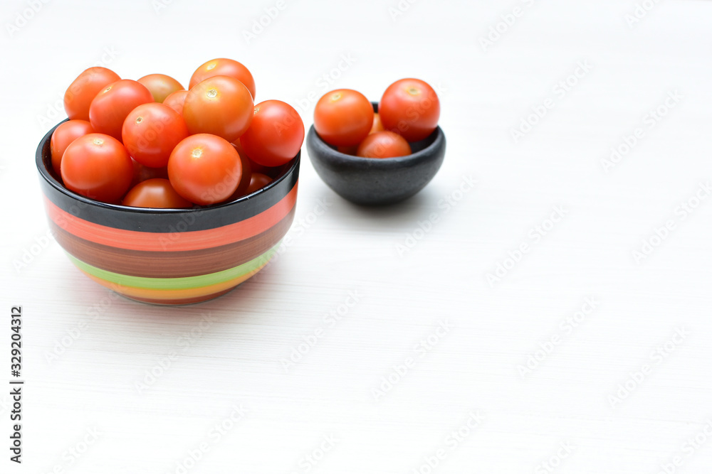 Fresh cherry tomato, displayed in containers on white wooden background Fresh cherry tomato, displayed in containers on white wooden background