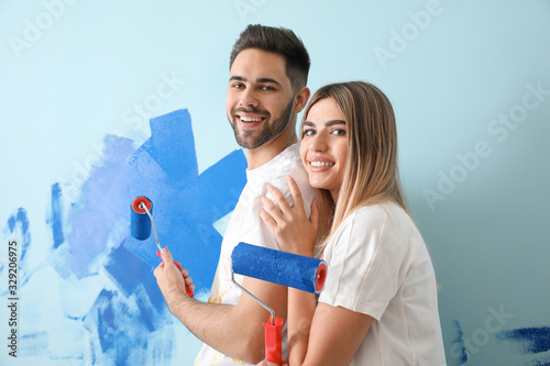 Happy young couple painting...