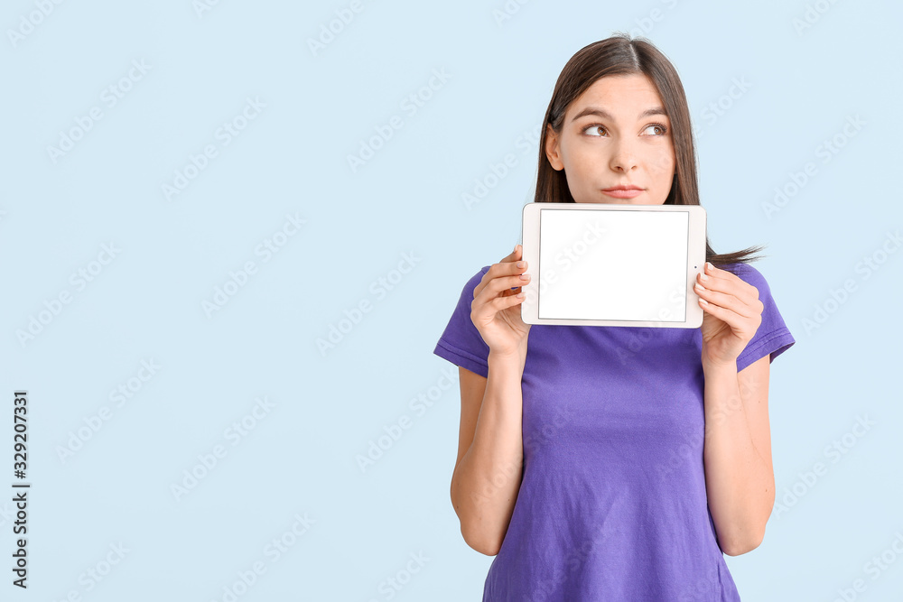Thoughtful young woman with tablet computer on light background Thoughtful young woman with tablet computer on light background