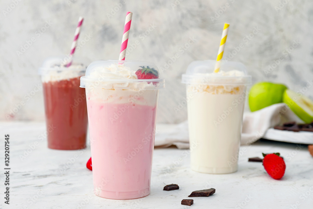 Cups of tasty milkshakes on white background Cups of tasty milkshakes on white background