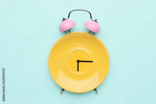 Photography Creative alarm clock made with plate on color background