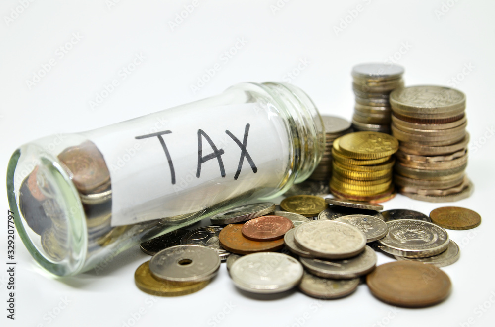 Tax lable in a glass jar with coins spilling out Tax lable in a glass jar with coins spilling out