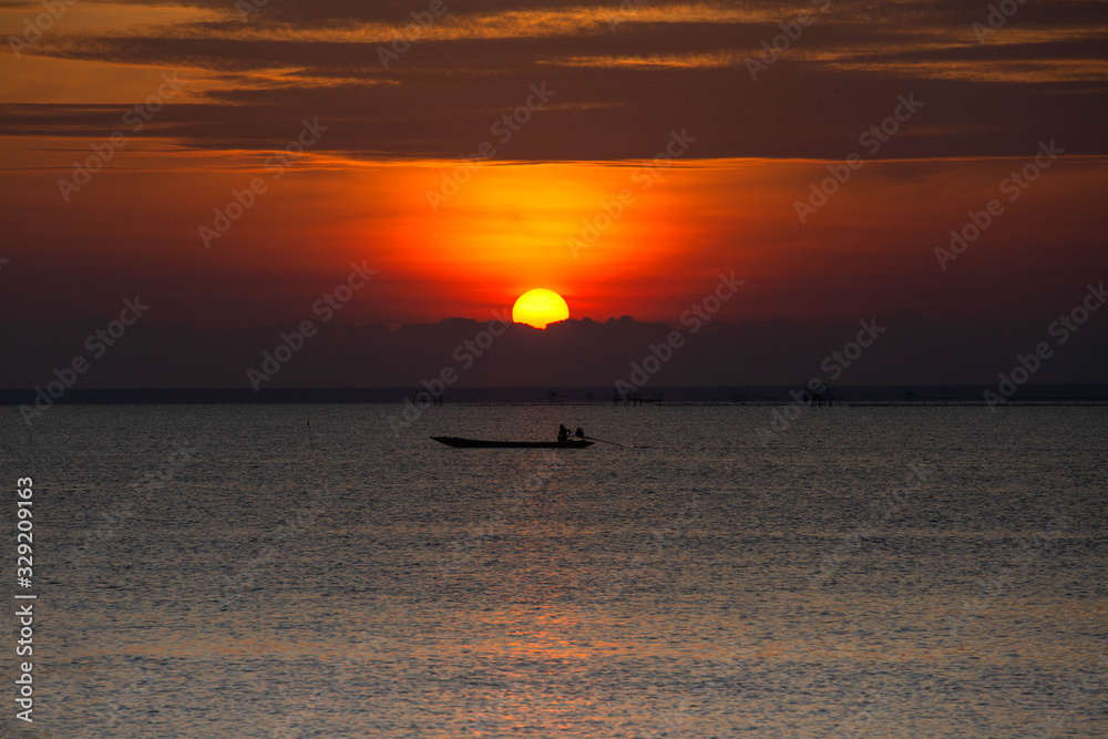 The morning sunrise at the beautiful seashore has a fisherman's boat to go fishing.
