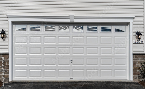 Fotografia, Obraz Double car classic insulated steel raised panel garage door framed with a white