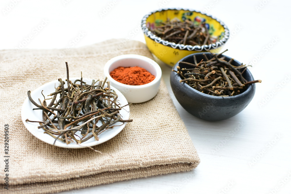 Fototapeta premium Saffron seasoning in root and powder, exhibited in containers on white wooden board