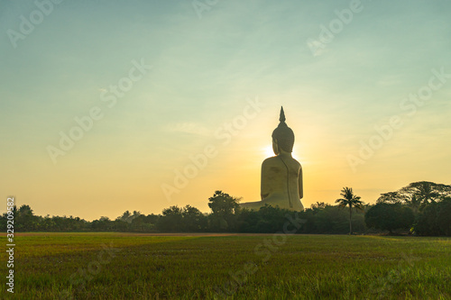sunrise above the great Buddha of Thailand at wat Muang Ang Thong Thailand. .The largest Buddha statue in the world Can be seen from afar Surrounded by rice fields.