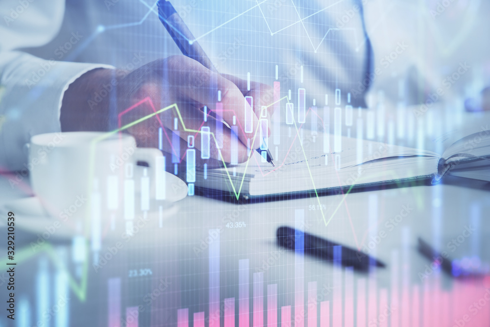 Double exposure of man's hands writing notes of stock market with forex chart. Double exposure of man's hands writing notes of stock market with forex chart.