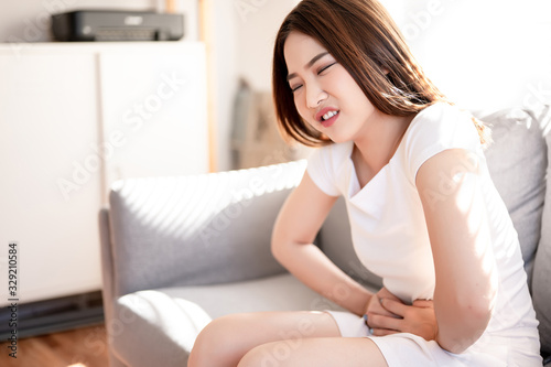 Asian a woman with menstrual cramps, stomachache torture. Healthy, pharmacy, self care concept.