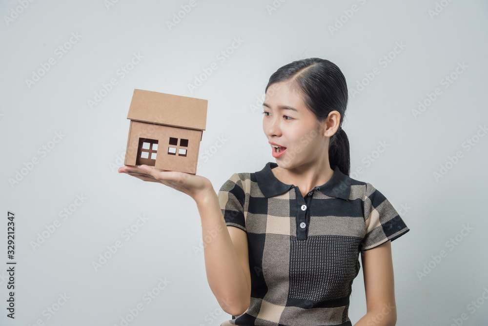 Young beautiful asian woman holding a house in her hands, black hairs. Young beautiful asian woman holding a house in her hands, black hairs.
