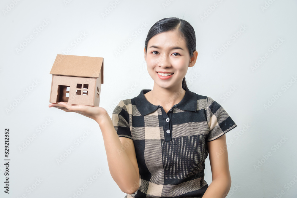 Young beautiful asian woman holding a house in her hands, black hairs. Young beautiful asian woman holding a house in her hands, black hairs.
