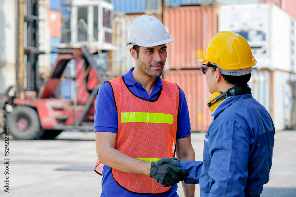 Technician and engineer shake hand in cargo container area with concept collaborate working.