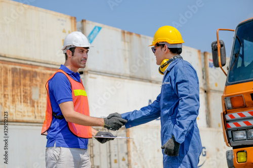 Technician and engineer shake hand in cargo container area with concept collaborate working. © narong
