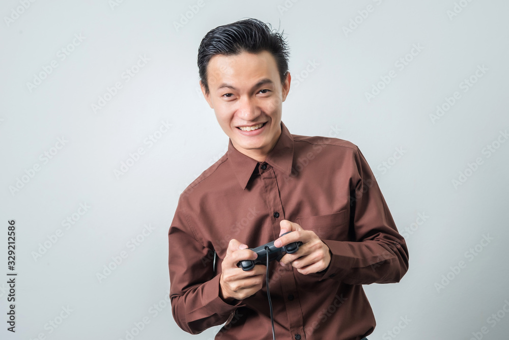 Young asian man playing video game with joystick, happy feeling. Young asian man playing video game with joystick, happy feeling.