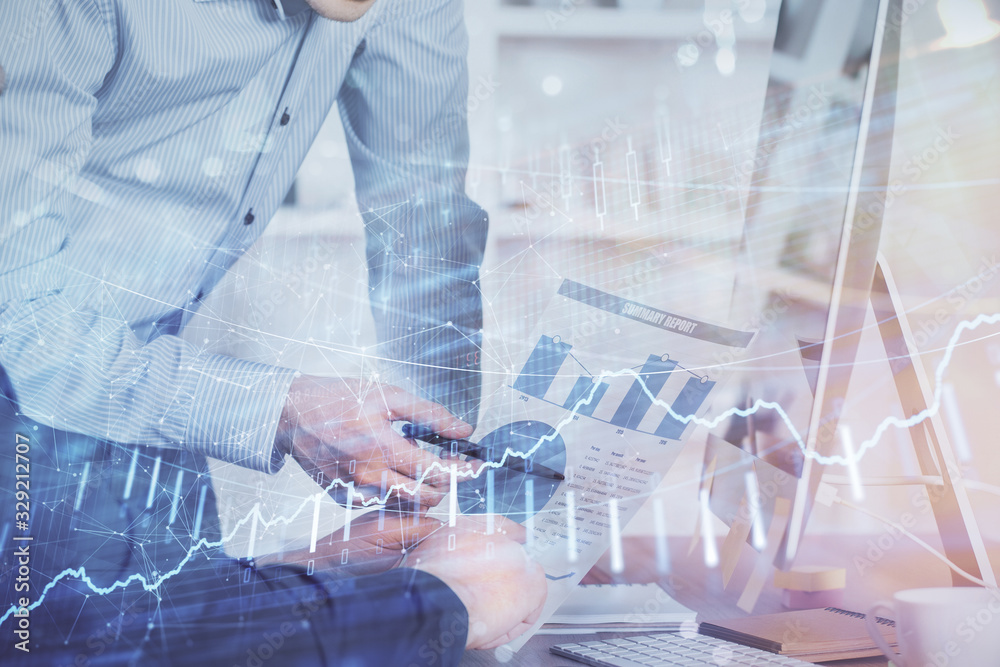 Double exposure of chart with businessman typing on computer in office on background. Concept of hard work. Double exposure of chart with businessman typing on computer in office on background. Concept of hard work.