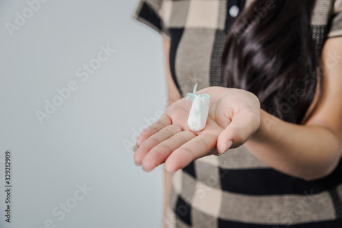 Young woman holding tampon feeling sick during critical day, gynecological health care, menstrual cycle.