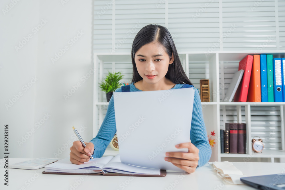 Business woman with paper house expense feeling happy, working alone in the room, she is black hair. Business woman with paper house expense feeling happy, working alone in the room, she is black hair.