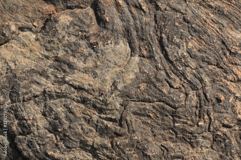 textures and patterns showing the formation of stone from ancient cooled lava flow on rock faces in a volcanic area rural Victoria, Australia.