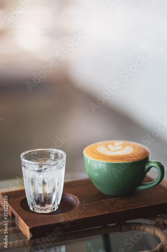A cup of Latte art on wood background