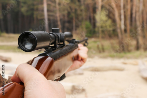 Air rifle with an optical sight in hand
