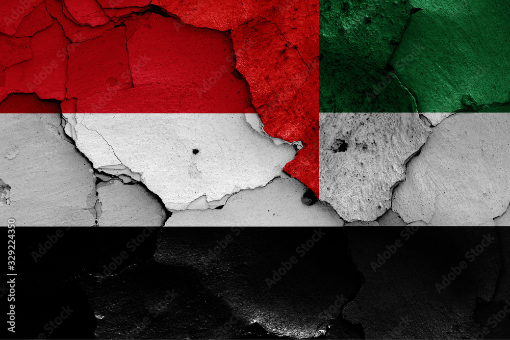 flags of Yemen and UAE painted on cracked wall