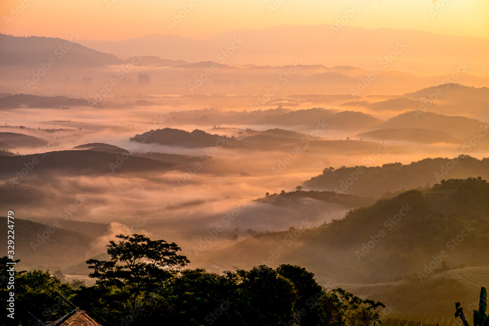 Beautiful Landscape of mountain layer in morning sun ray and winter fog at  Chiangrai, Thailand