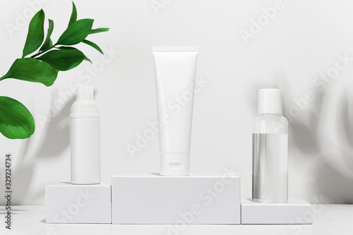 Wallpaper Mural Cream tube, moisturizing foam in spray and tonic water on shipping boxes. White blank unbranded flacons with cosmetology products. Professional skincare and wellness concept Torontodigital.ca