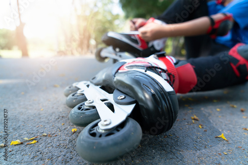 Little boy setting of laces on black roller skates