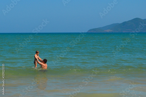 Father and son are swimming in the sea on a summer lifestyle vacation . Tourist destination