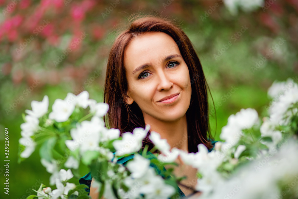beautiful young brunette woman standing near the apple tree on a warm summer day beautiful young brunette woman standing near the apple tree on a warm summer day