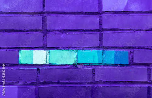 Beautiful bright colorful street art graffiti. Urban grunge bricks background with copyspace on the brick walls of the city. Blue, neon, violet rough vinrage texture